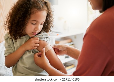 Covid nurse vaccinating child putting a bandage on at a clinic. Doctor applying plaster on girl after an injection at health centre. Pediatric, immunity and prevention at medical childrens hospital - Shutterstock ID 2191140195