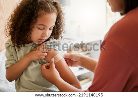Covid nurse vaccinating child putting a bandage on at a clinic. Doctor applying plaster on girl after an injection at health centre. Pediatric, immunity and prevention at medical childrens hospital