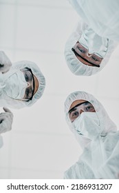 Covid, Pandemic And Team Doctors, Scientists Or Medical Workers Wearing Protective Ppe To Prevent Spread Of A Virus From Below. Virologist Group Wearing Hazmat Suit For Plaque, Ebola Or Disease