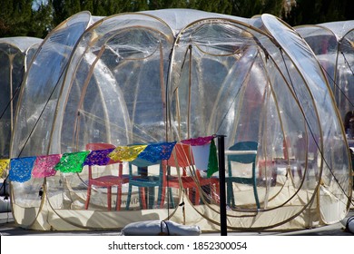 COVID Restaurant Seating In A Clear Plastic Bubble Complete With Chairs Inside During The COVID Pandemic.