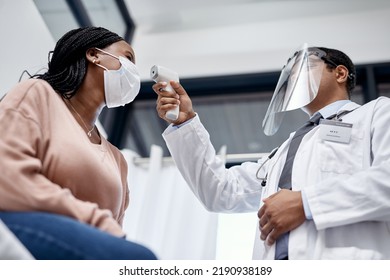 Covid Screening With A Doctor Measuring Temperature Of A Patient Using An Infrared Thermometer During An Appointment Or Checkup. Female Getting Tested For Corona Virus And Wearing A Mask From Below