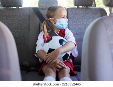 Covid, Soccer And Girl In A Car To Travel In Backseat To A Youth Football Training Game For Exercise And Training. Face Mask, Coronavirus And Young Child In Traffic Traveling To A Kids Sports Match