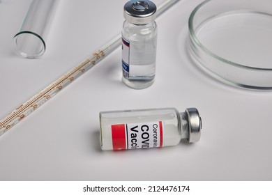 Covid Vaccine And Chemical Glassware - Labs Photo. Coronavirus Antivirus Solution Inside Glass Bottle. Immunization Shot On Lab Desk. Antiviral Therapy Against Coronavirus And Flu Infections.