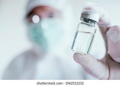COVID vaccine manufacturers. Doctor or researcher holding coronavirus vaccine bottle. Immunization and treatment. Medicine vial. Healthcare and medical development concept.