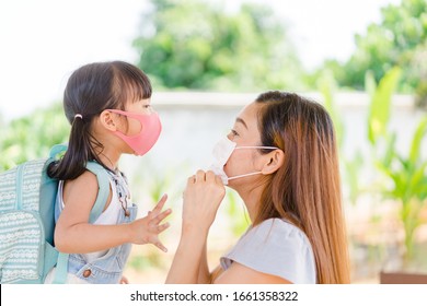 Covid-19 and Air pollution pm2.5 concept.Little chinese girl and chinese mother holding her kid wearing mask for protect pm2.5 in the garden at home.Covid-19 coronavirus and epidemic virus symptoms. - Powered by Shutterstock