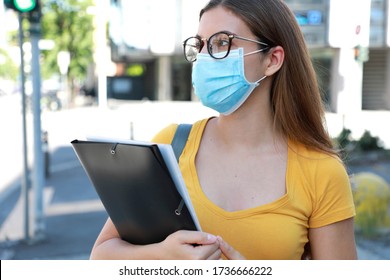 COVID-19 Beautiful University Student Female With Surgical Mask Walking In City Street. College Girl Back To School During Pandemic Coronavirus Disease 2019.