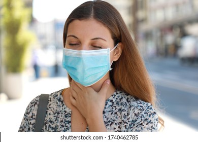 COVID-19 Close Up Woman Wearing Surgical Mask With Sore Throat Outdoor. Portrait Of Woman With Face Mask Against SARS-CoV-2 Suffering Throat Pain In City Street.