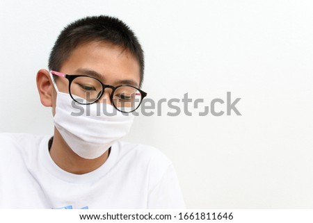 Covid-19 , Coronavirus and Air pollution pm2.5 concept.  An Asian boy is wearing mass to protect against small dust and germs that are currently spreading around the world: Corona virus, Covid-19