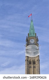 COVID-19 Coronavirus Concept In Canada, Parliament Tower With Face Mask. COVID Affects Canadians. 