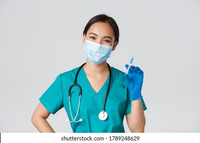 Covid-19, Coronavirus Disease, Healthcare Workers Concept. Smiling Cheerful Asian Doctor, Nurse In Medical Mask And Rubber Gloves Prepare Syringe With Vaccine For Shot Vaccination, White Background