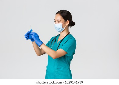 Covid-19, Coronavirus Disease, Healthcare Workers Concept. Profile Of Asian Female Doctor, Nurse In Medical Mask And Globes, Fill Syringe With Vaccine, Doing Vaccination Shots, White Background