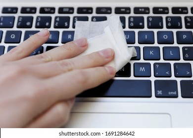 COVID-19 Coronavirus disinfection of workspace cleaning disinfecting wipes to wipe surface of desk, keyboard, mouse at office. Stop the spread of corona virus. Woman cleaning the keyboard.  - Powered by Shutterstock