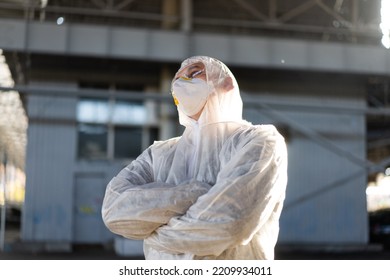 COVID-19 Coronavirus Doctor Standing Hospital Parking Dressed White Protective Overalls Hazmat Suit. Infectious Disease Pandemic Medical Worker Front Line, Outbreak. Male Medical Worker Medium Shoot