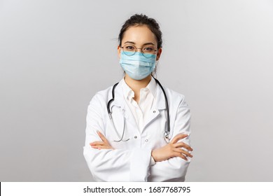Covid19, coronavirus, healthcare and doctors concept. Portrait of professional confident young asian doctor in medical mask and white coat, stethoscope over neck, ready help patient, fight disease