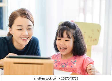 Covid-19 Coronavirus And Learning From Home, Home School Kid Concept.Little Asian Girl Study With Online Learning And Asian Mother Work From Home With Laptop.Education And Social Distancing Concept.