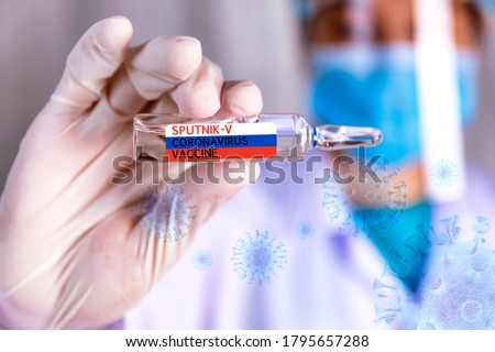 Covid-19 coronavirus vaccine Close up hands of scientist show Covid-19 vaccine name sputnik-v in glass vial with virus background Hands of doctor wear rubber glove holding Covid-19 vaccine in bottle