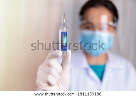 Covid-19 coronavirus vaccine. Close up hands of scientist show Covid-19 vaccine in glass vial. Hands of doctor wear latex glove holding Covid-19 vaccine in glass vial. Healthcare and medical concept.