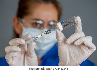 COVID-19 Coronavirus Vaccine. Doctor scientist with syringe analyzing virus Sars-CoV-2 in research for vaccine to be ready for clinical trial. Female researcher testing potential vaccine at the lab. - Shutterstock ID 1708463248
