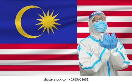 Covid-19 Frontliners Pray For Malaysia During The Pandemic 4th Wave With Malaysia Flag Background. 