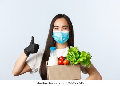 Covid-19, Grocery Store, Employment, Small Business And Preventing Virus Concept. Confident And Cheerful Shop Employee, Cashier In Medical Mask And Gloves Provide Safe Shopping During Coronavirus