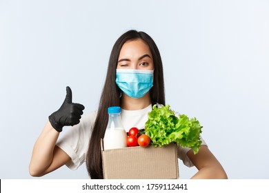 Covid-19, Grocery Store, Employment, Small Business And Preventing Virus Concept. Ccheerful Shop Employee, Cashier In Medical Mask And Gloves Provide Safe Shopping During Coronavirus, Thumb-up