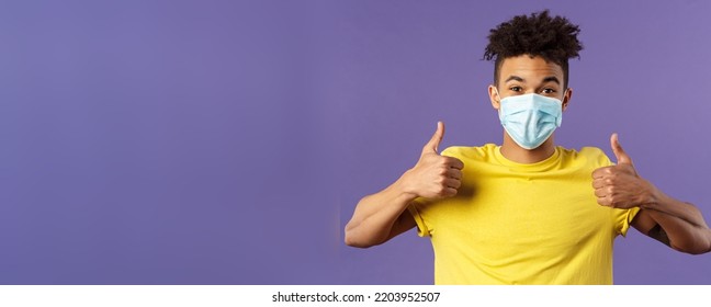 Covid19, Healtcare And Medicine Concept. Enthusiastic Happy Spanish Guy In Facial Mask, Show Thumbs-up And Smiling With Eyes, Excited, Support Social-distancing, Prepared For Going Grocery Shopping