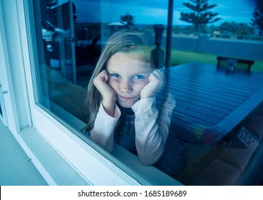 COVID-19 Lockdowns. Depressed And Lonely Little Girl Looking Through The Window During Quarantine. Child Feeling Sad As Coronavirusu Pandemic Forces Families To Stay Home In Self Isolation.