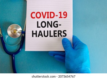 COVID-19 long-haulers covid symptoms symbol. White card with words Covid-19 long-haulers. Doctor hand, stethoscope, blue background, copy space. Medical, COVID-19 long-haulers covid symptoms concept.