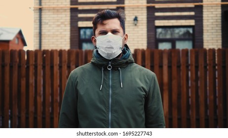 COVID-19 Man in city street wearing face mask protective for spreading of Coronavirus Disease in europe. Portrait of man with surgical mask on face against SARS-CoV-2.