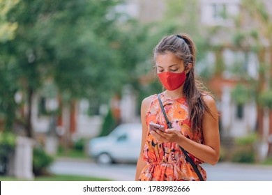 COVID-19 mask wear mandatory in city. Asian woman walking using mobile phone wearing face mask protection as prevention for coronavirus outside in city park summer lifestyle outdoor. Corona virus. - Powered by Shutterstock