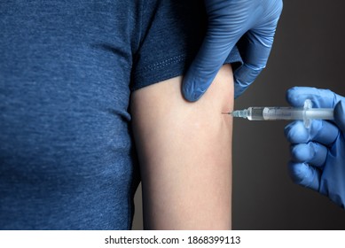 COVID-19 or monkeypox vaccine injection, doctor in gloves holds syringe and makes vaccine jab to woman patient arm. Concept of coronavirus, flu, vaccination, smallpox therapy, shot and treatment. - Powered by Shutterstock