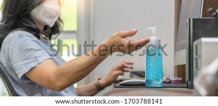 Covid-19 outbreak, coronavirus pandemic prevention with woman with n95 face mask cleaning hand with alcohol gel sanitizer during work at home quarantine for hygience antibacteria safety