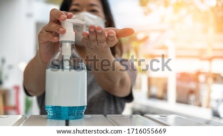 Covid-19 outbreak, coronavirus pandemic prevention with woman with n95 face mask cleaning hand with alcohol gel sanitizer during stay at home quarantine for hygience antibacteria safety