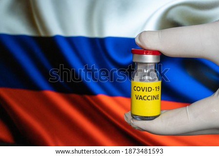 COVID-19 Pandemic Coronavirus concept. Russia Coronavirus vaccine, Sputnik V. Covid-19 vaccination, flu prevention, immunization concept with Russian Flag at background. Spoutnik V new russia vaccine.