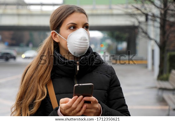 COVID-19\
Pandemic Coronavirus Mobile Application - Young Woman Wearing Face\
Mask Using Smart Phone App in City Street to Aid Contact Tracing in\
Response to the 2019-20 Coronavirus\
Pandemic