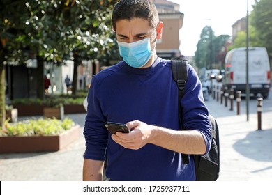 COVID-19 Pandemic Coronavirus Worried Young Man Wearing Surgical Mask Using Smart Phone App in City Street to Aid Contact Tracing and Self Diagnostic in Response to the Coronavirus Pandemic 2019 - Shutterstock ID 1725937711
