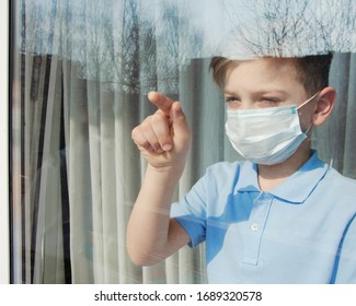 COVID-19 Pandemic Coronavirus.Home isolation.Little boy with face mask outside window. - Shutterstock ID 1689320578
