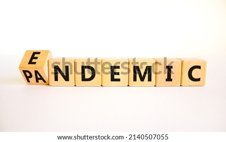 Covid-19 pandemic or endemic symbol. Turned wooden cubes and changed the concept word Pandemic to Endemic. Beautiful white background copy space. Medical Covid-19 pandemic or endemic concept.