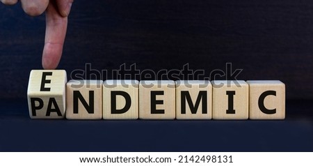 Covid-19 pandemic or endemic symbol. Turned wooden cubes and changed the concept word Pandemic to Endemic. Beautiful grey background copy space. Medical Covid-19 pandemic or endemic concept.