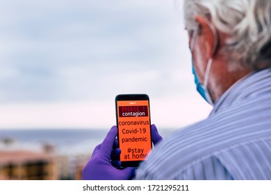 Covid-19 Pandemic, Global Emergency, Senior Man Receives A Message On His Cell Phone On Phase 1. Stay At Home To Avoid Contagion By Coronavirus