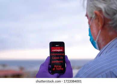 Covid-19 Pandemic, Global Emergency, Senior Man Receives A Message On His Cell Phone On Phase 1. Stay At Home To Avoid Contagion By Coronavirus