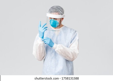 Covid-19, Pandemic, Healthcare Workers Fighting Virus Outbreak. Serious Medical Worker, Doctor Put On Personal Protective Equipment PPE, Gloves Before Entering Patients Room With Coronavirus Case