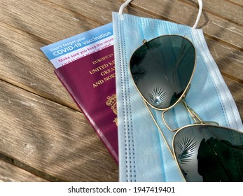 Covid-19 Passport, London, UK - 03.31.2021: Covid 19 Vaccine Passport Concept  For Restrictions On Travel With Sunglasses, UK Passport And Covid Mask And Vaccine ID Card 