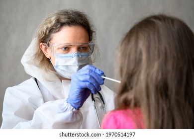 COVID-19 PCR Test In School, Doctor Holds Swab For Mucus Sample From Kid Nose Or Mouth. Portrait Of Nurse Working With Child During Corona Virus Pandemic. Concept Of Coronavirus And Monkeypox Testing