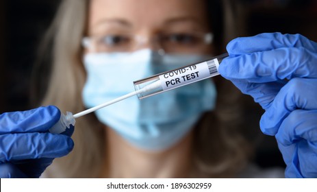 COVID-19 PCR Test, Swab Collection Kit In Doctor's Hands, Woman In Medical Face Mask Holding Tube Of  PCR Test In Lab. Concept Of Coronavirus Nasal Diagnostics, Molecular Analysis And Saliva Sample.