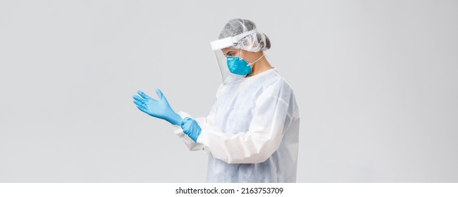 Covid-19, Preventing Virus, Health, Healthcare Workers And Quarantine Concept. Young Doctor In Personal Protective Equipment, Nurse Put On Rubber Gloves To Work With Coronavirus Sick Patient