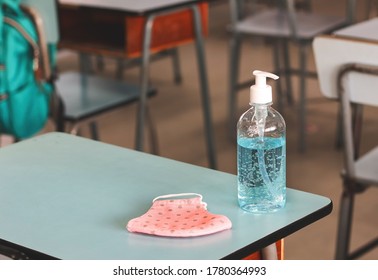 Covid-19 prevention , back to school,new normal concept.Alcohol sanitizer  hand  gel and pink polka dots fabric mask folded on school desk in  the classroom . - Powered by Shutterstock