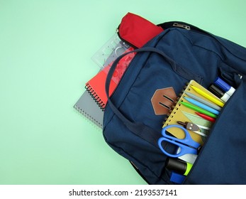     As COVID-19 prevention goes back to school and new normal concept. Top view of backpack with school supplies, mask and disinfectant gel on green background.              - Shutterstock ID 2193537141