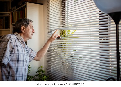 COVID-19 Quarantine Mental Health. Elderly Man Looking Out On Window, Isolation, Loneliness, Social Distancing