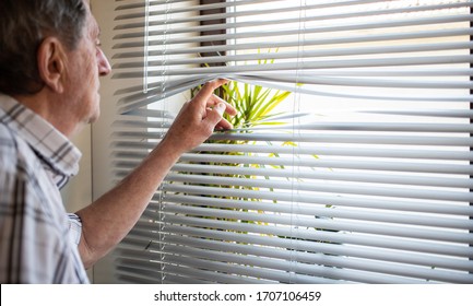 COVID-19 Quarantine Mental Health. Elderly Man Looking Out On Window, Isolation, Loneliness, Social Distancing